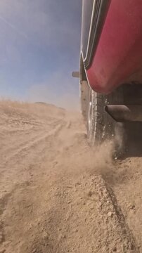 Vehicle drives fast through dusty terrain