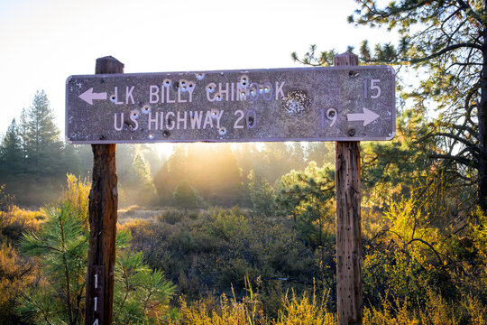 Weathered Bullet-Riddled Highway Direction Sign to Lake Billy Chinook at Sunrise in Central Oregon
