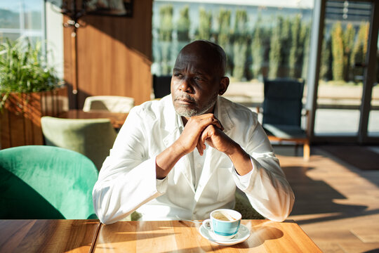 Mature man thinking at a cafe with coffee