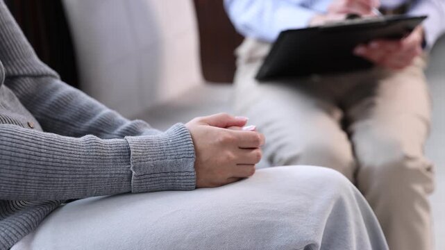 Mental health. Professional psychologist making notes during therapy session with patient indoors, closeup