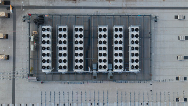 Aerial view of industrial HVAC ventilation and cooling fans arranged in rows on a flat rooftop in Peterborough, England, United Kingdom.