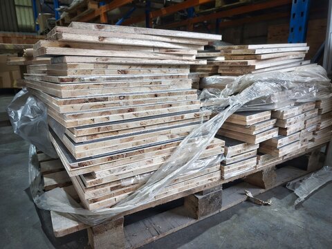Stacked blockboard plywood panels on wooden pallet in warehouse factory