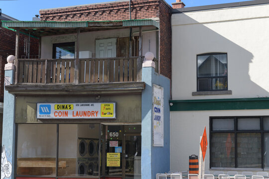 exterior building facade and sign of Dina's Coin Laundry Inc, a laundromat, located at 650 Lansdowne Av, Toronto
