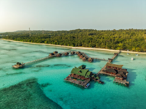 Aerial view of Maratua Island featuring turquoise waters, coral reefs, and white sandy beaches surrounded by the vast ocean in Berau, East Kalimantan, Indonesia.