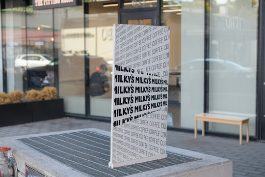 defocused view of Milky's Coffee sign and facade located at 1243 Dundas St W, Toronto