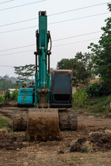 An excavator clears the way for road construction. Crawler excavator digger machine standing on dirt ground in rural construction site © Semoga