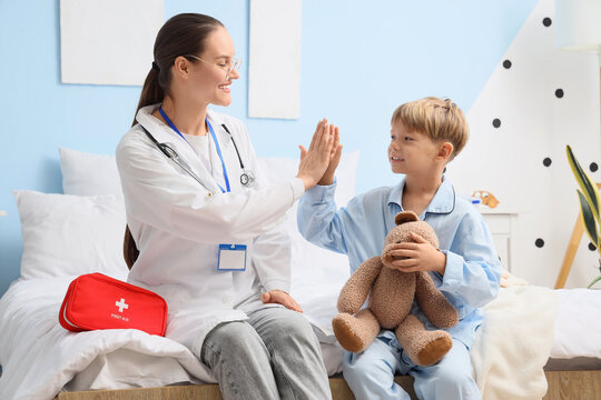 Pediatric healthcare and child wellness, doctor giving high five to young boy patient in bedroom for positive medical consultation and recovery support