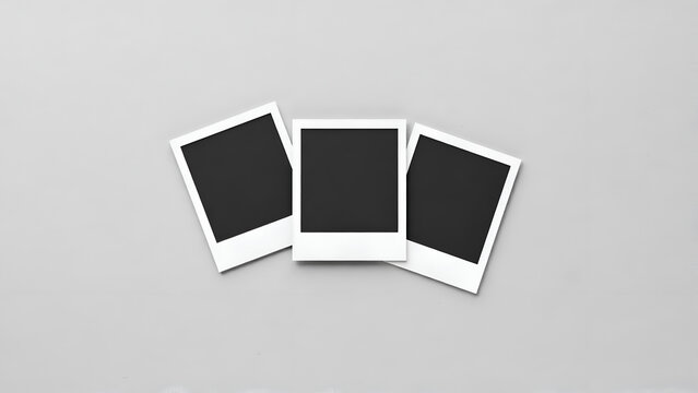 Three blank instant photo frames arranged in a row on a plain light gray background, top view, minimalist style for photography mockups and creative projects