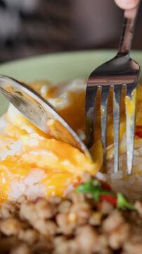 Cutting Runny Fried Egg Yolk on Thai Pad Krapow Rice