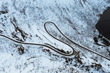 Fototapeta premium Drone shot of a snowy winding road in Norway