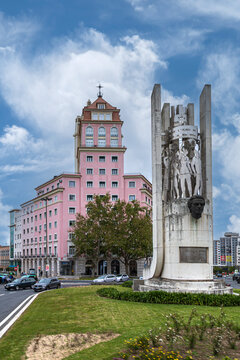 Lisbon, Portugal - April 6, 2024: The Francisco S&aacute; Carneiro Monument featuring a concrete structure with bas-reliefs, a bronze bust, and the landmark pink tower building in Areeiro.