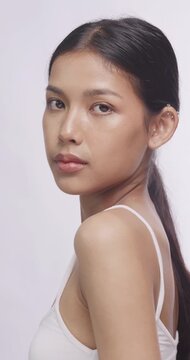 Asian model looking back over her shoulder at camera. She poses gracefully showing clean skin.