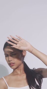 Beautiful Asian woman with tanned skin is worried about her face being exposed to bright sunlight during the day.