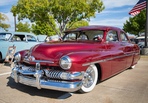 Front side view of a red 1951 Mercury Eight classic car.