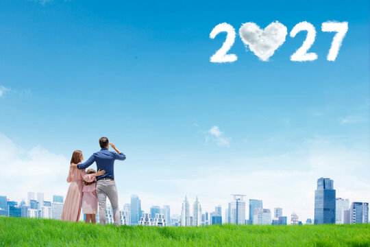 Happy Family Looking at 2027 Heart Cloud Text over City Skyline