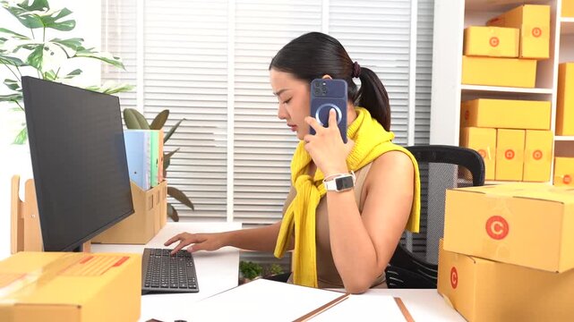Entrepreneurial Spirit: A young businesswoman on the phone juggles tasks at her desk, surrounded by packages ready for shipment, embodying the hustle of a small business owner.