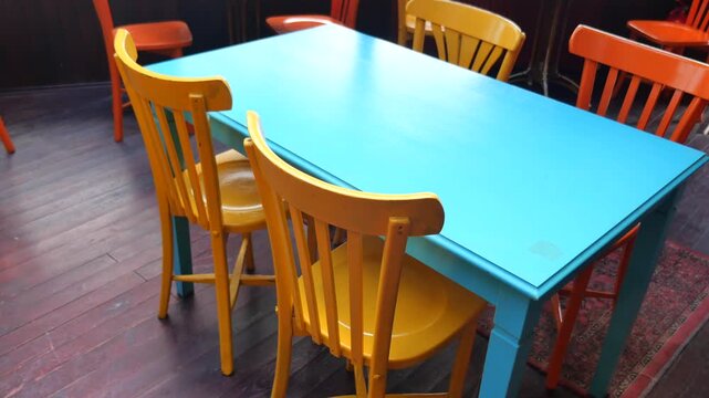 Colorful chairs around a blue table in a cafe setting