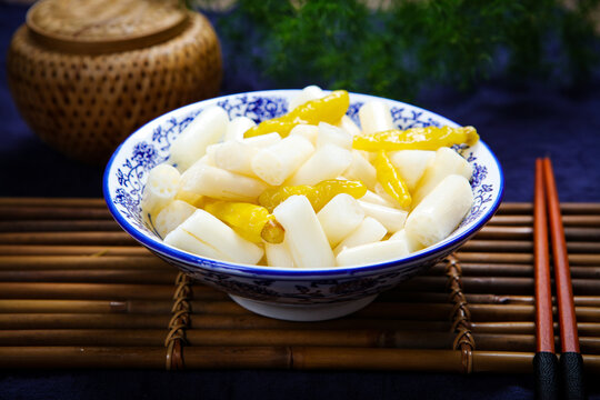 Pickled lotus stems with wild chili on white plate
