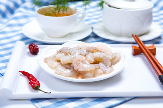 Raw peeled shrimps served on white ceramic plate