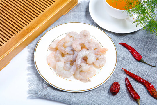 Raw peeled shrimps served on white ceramic plate