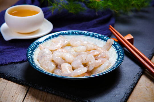 Raw peeled shrimps served on white ceramic plate
