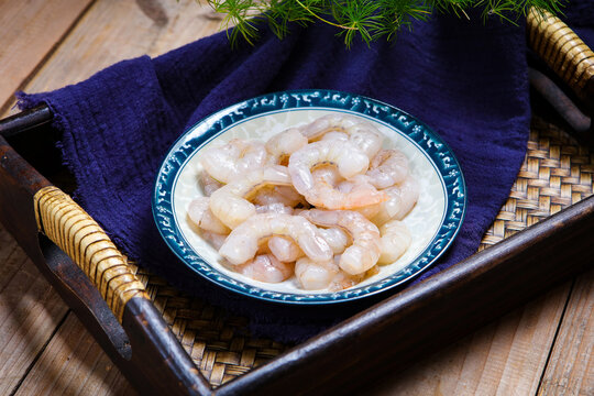 Raw peeled shrimps served on white ceramic plate