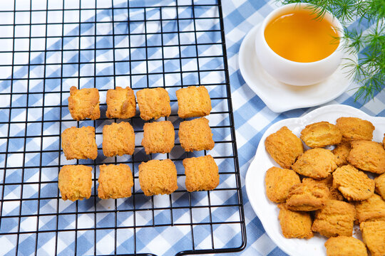 Traditional crispy cookies with teacup on checkered tablecloth