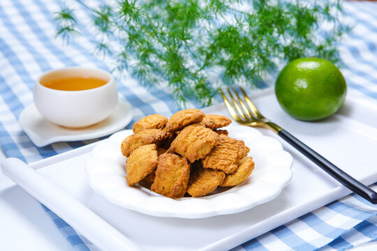 Traditional crispy cookies with teacup on checkered tablecloth