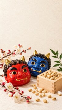 Red and blue oni ogre masks with roasted soybeans in wooden masu box and plum blossoms for Japanese setsubun festival background