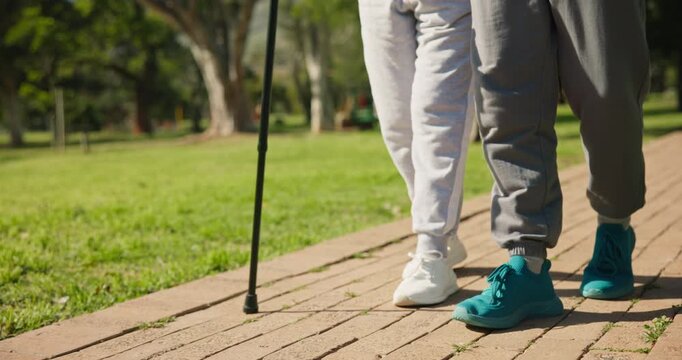 Walking, outdoor and old couple with cane, legs and bonding with partner and assistance in nature. Retirement, connection and senior person with disability, wellness and travel with spouse at park
