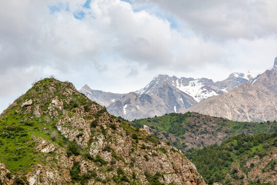 Majestic mountains rise under cloudy skies