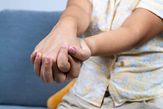 Woman relieving joint pain with hand massage and knuckle stretch