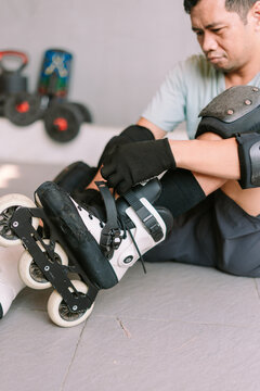 Person wearing protective gear while fastening inline skates