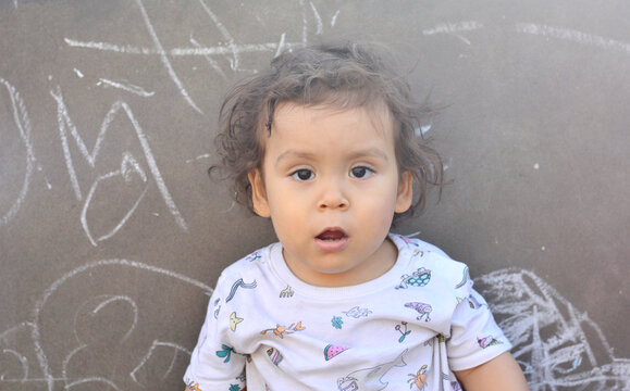 Toddler with messy hair shows surprise.