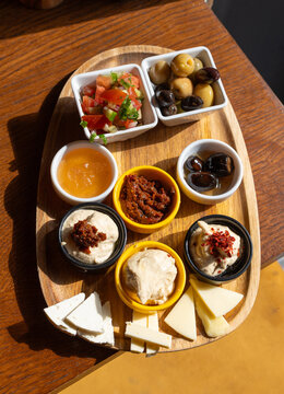 Breakfast appetizer snacks including cheese, hummus, pickled olives