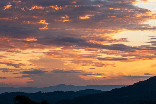 Blue golden sky sunrise dramatic beautiful landscape mountain. Dramatic sunset over mountain landscape. Beautiful landscape foggy hills twilight time. Dawn sky gold dusk time cloudscape with sunlight