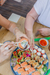Woman dipping a fresh sushi roll in soy sauce © Cavan