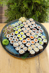 Large platter of assorted maki sushi on a wooden table © Cavan