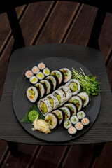 Overhead view of assorted sushi rolls on a black platter © Cavan