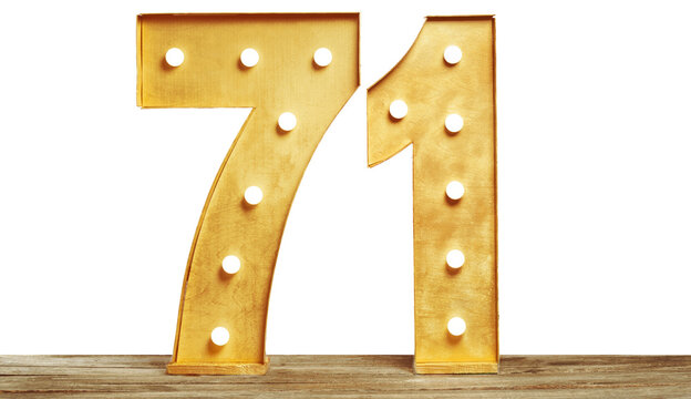 Large light-up number 71 made of gold-colored material displayed on a wooden surface