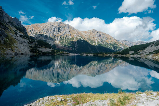 A mountain pond with reflecting peaks. The Black Pond below Rysy in the Tatra Mountains. Czarny Staw pod Rysami. Tatry Wysokie.	