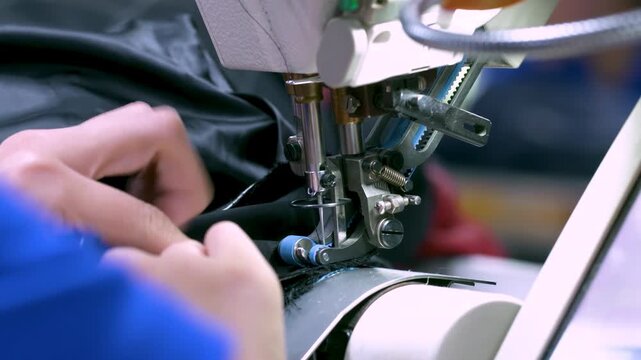 Industrial large size textile factory, seamstress female textile workers stitching fabrics on industrial needle sewing machines worker in garment manufacturing on production line assembly line