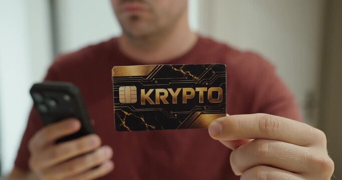 Close-up of a man holding a crypto payment card while using a smartphone. Concept for cryptocurrency, mobile payments, blockchain and digital finance.