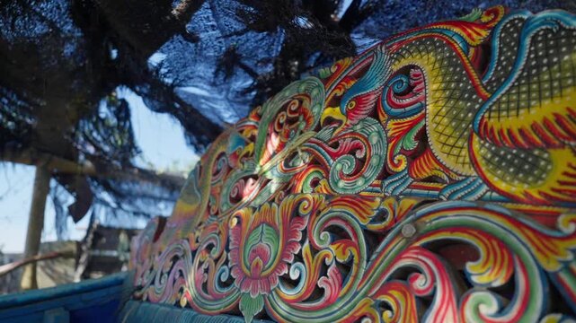 Slow motion close up of ornate carving on kolae boat in Pattani Thailand