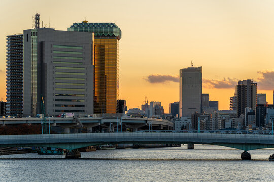 Tokyo city skyline and Kototoi Bridge over Sumida River at sunset golden hour. Tokyo, Japan.