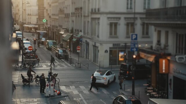 People crossing a busy parisian street at sunset