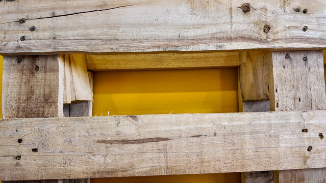 Wooden Pallet Background with Bright Yellow Color Behind Planks