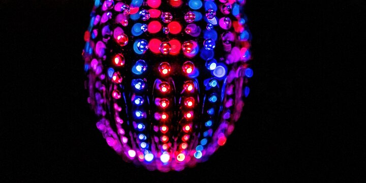 Numerous tiny lights create a glowing pattern on a dark background.