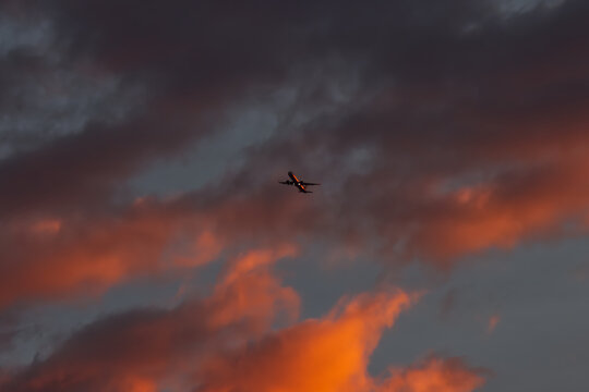 A passenger airplane taking off against a dramatic morning sky.