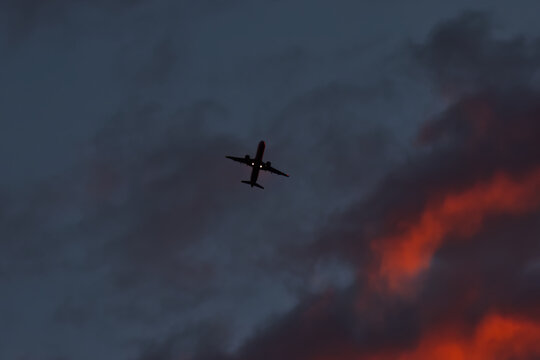 A passenger airplane taking off against a dramatic morning sky.